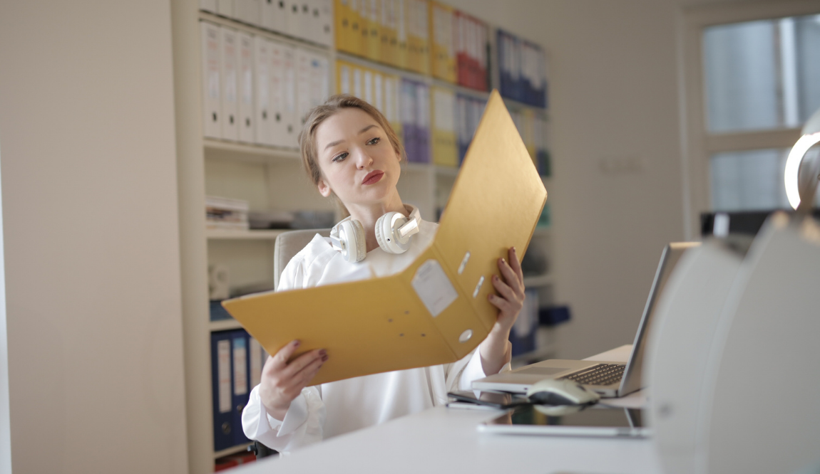 Gestionnaire qui consulte des dossiers d'archives papier